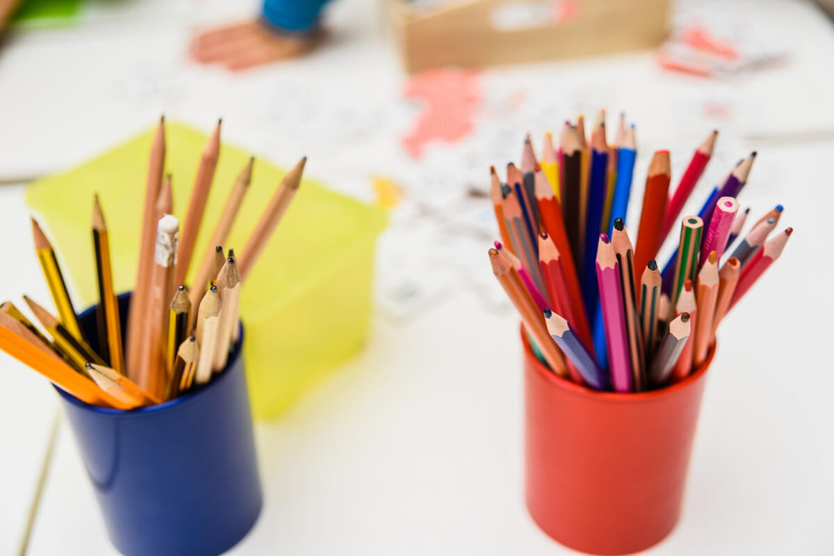 To bokser fylt med blyanter og fargeblyanter står klare til bruk på et kreativt verksted