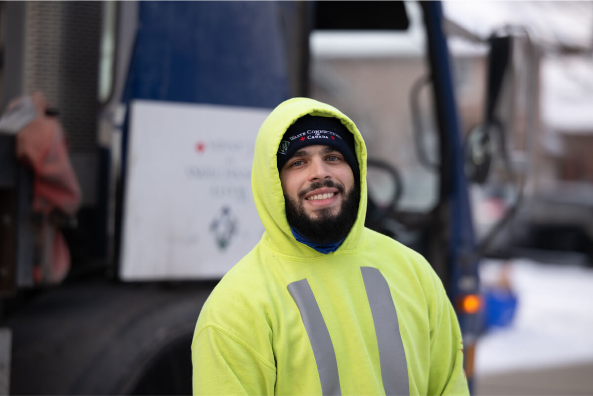 Waste Connections crew member managing garbage removal container rental with care.