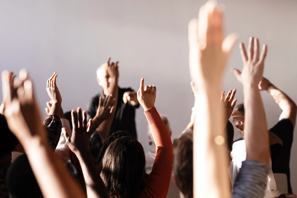 Lecture being giving with lots of hands raised