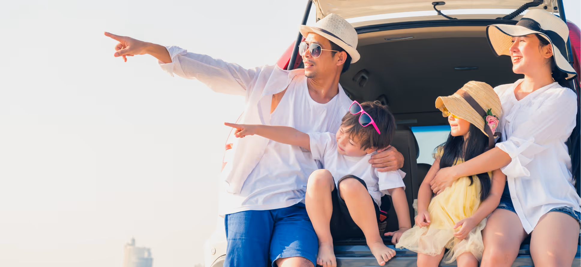 A family on the back of an SUV gazing at the horizon