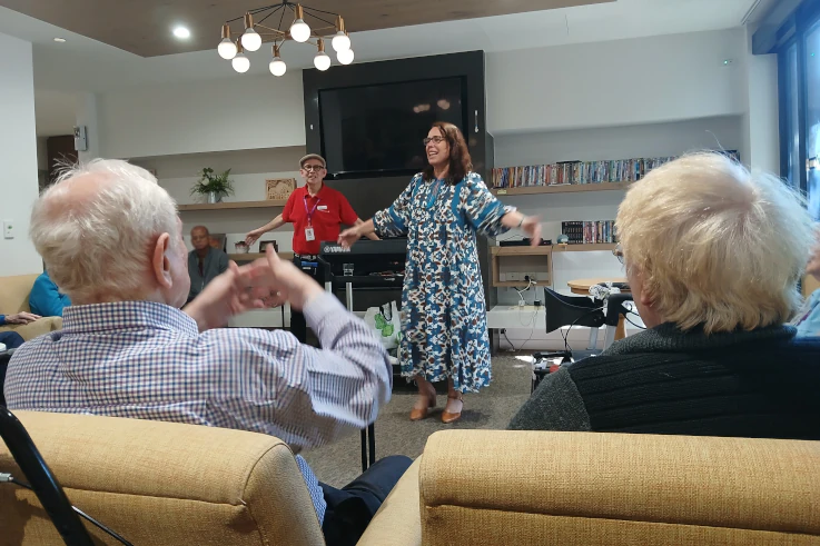 Music therapy session with Zita. Residents clap and sing along while she leads.