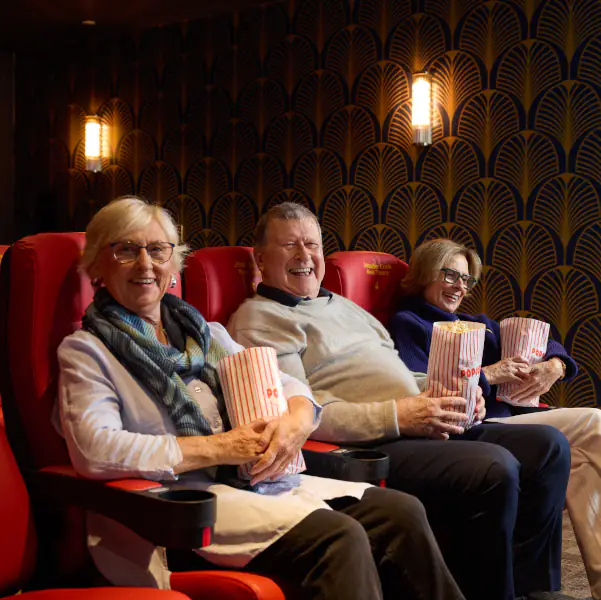 A group of residents enjoy popcorn at the movie theatre.