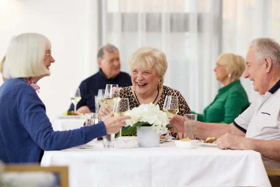 Mayflower residents enjoying a glass of wine at dinner.