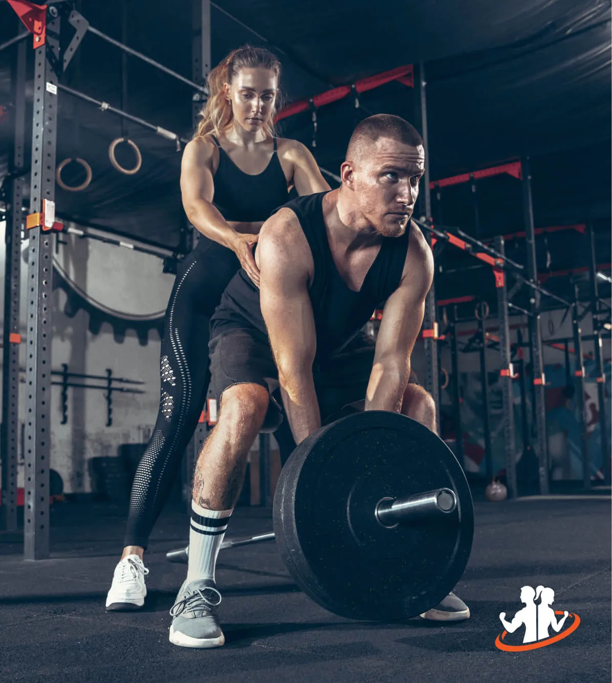 Trainer guiding a man lifting a barbell