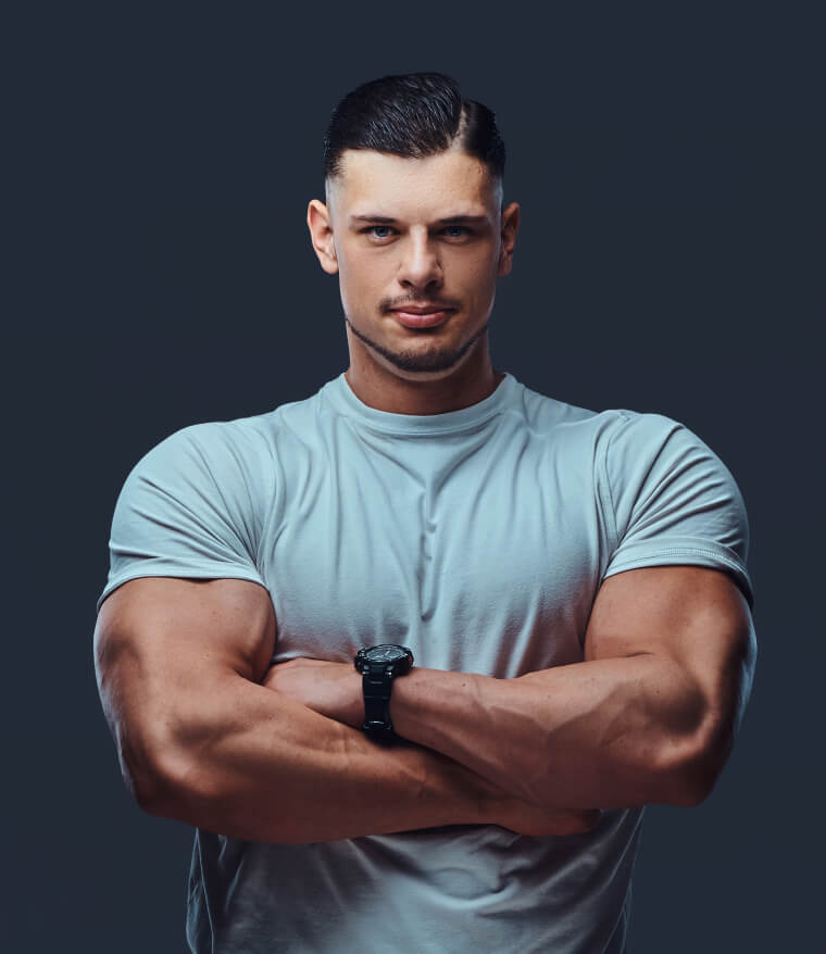 Man in a light blue workout top with arms folded