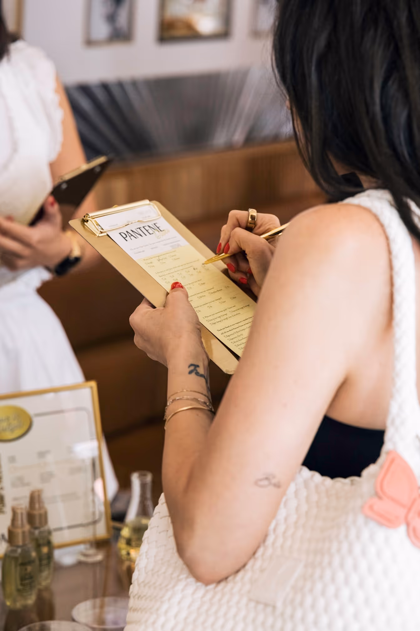 Guest filling out a Pantene form at the dinner event.