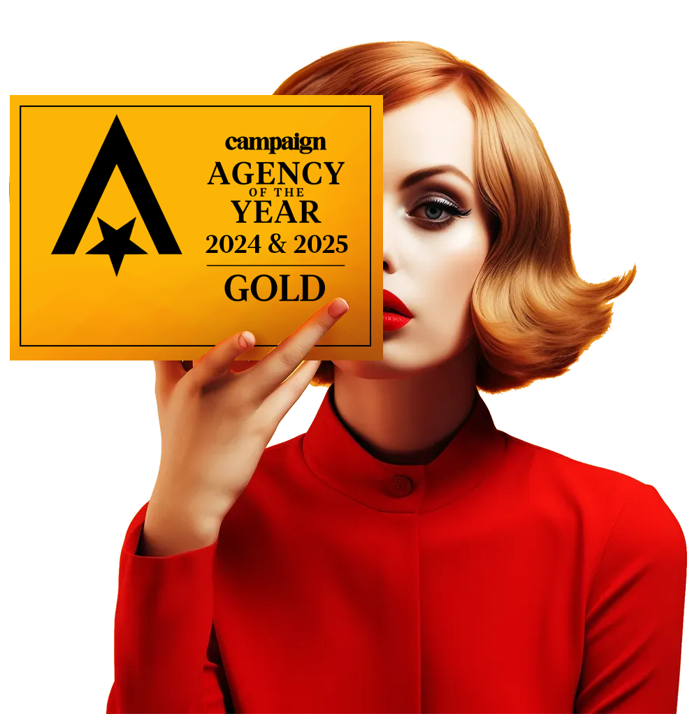 Woman holding a gold plaque reading 'CampaignAgency of the Year Gold in 2024 & 2025'.