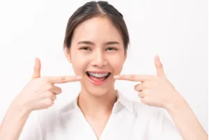 A girl pointing at her self-ligating braces.