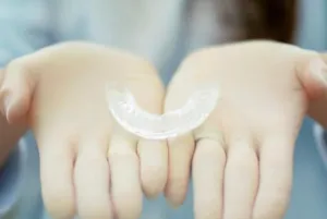 A girl’s hand holding a hybrid retainer