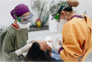 Dentists treating a patient's chipped teeth