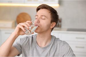  A man drinking water from a glass