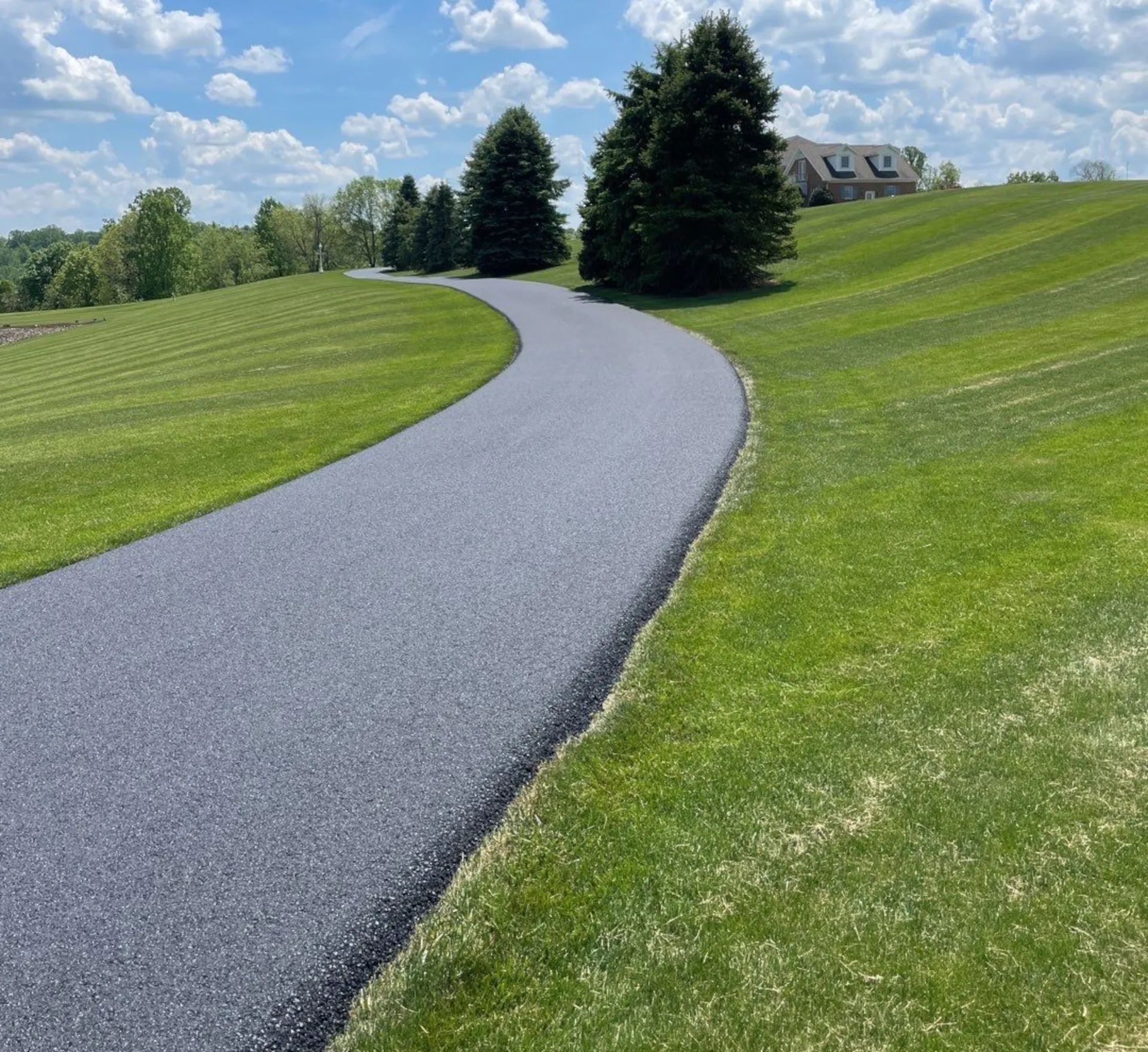 long private driveway that is freshly paved