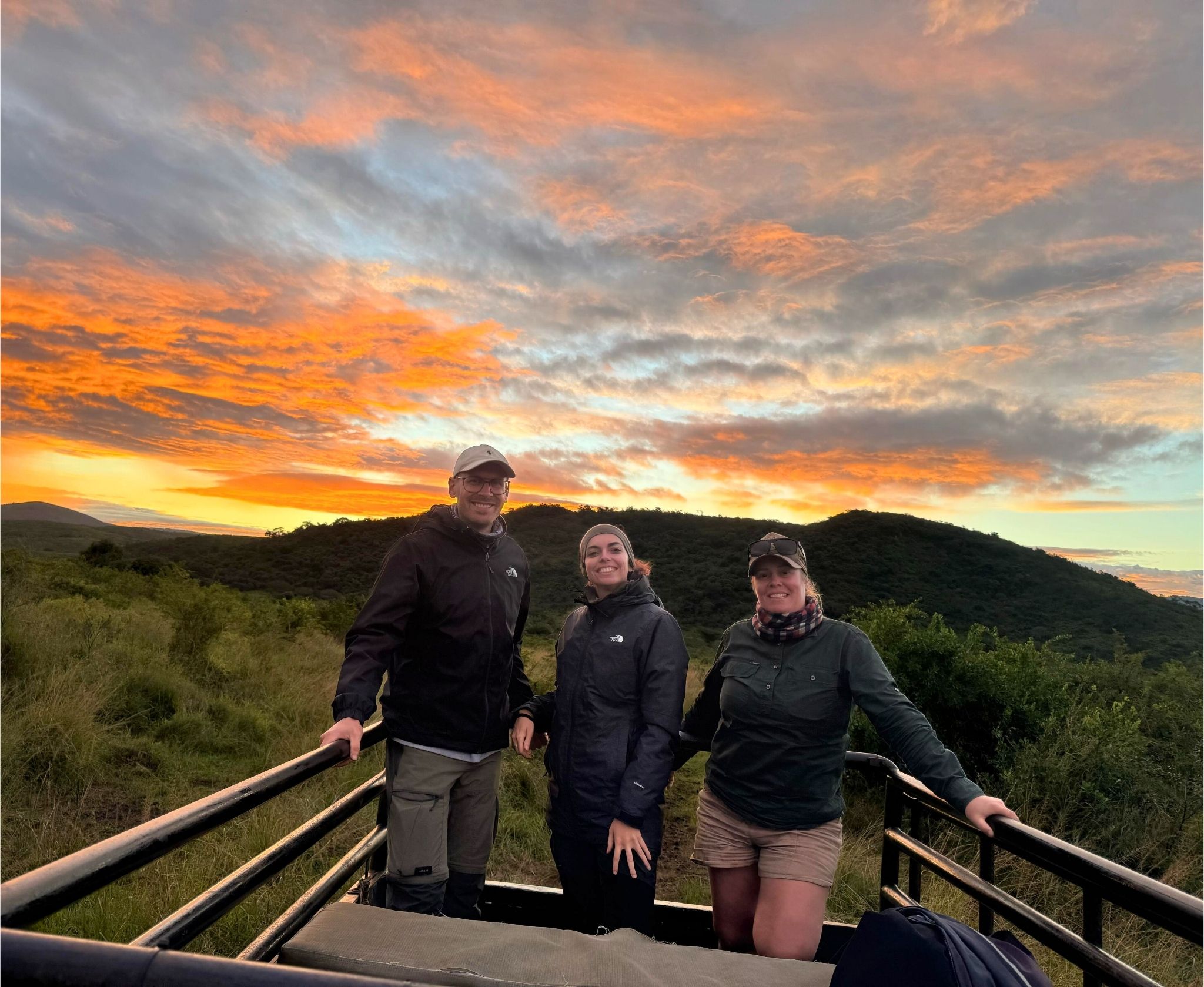 Wildlife volunteers on a monitoring vehicle at sunrise in South Africa, starting their conservation fieldwork with Wildlife ACT.