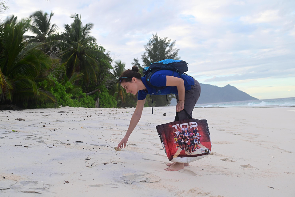 A dedicated marine conservation volunteer conducting fieldwork or a beach cleanup on a sandy coast.