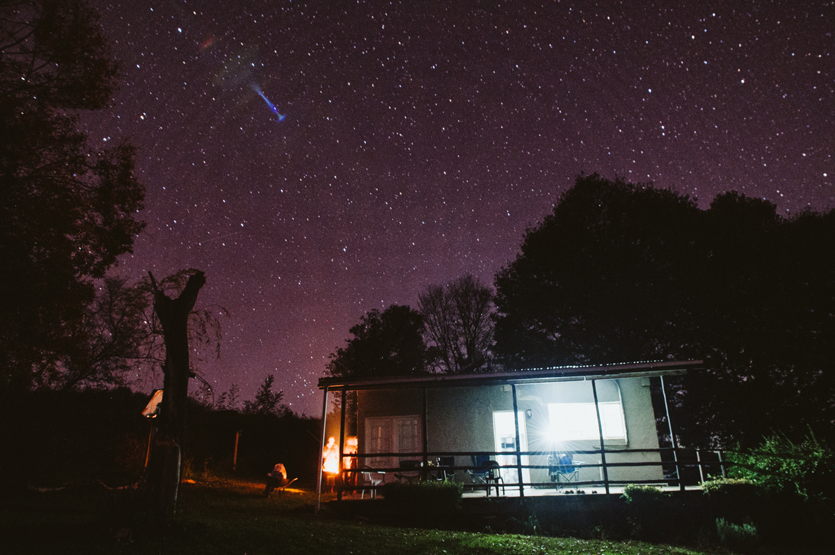 A night-time view of the Wildlife ACT field accommodation in the Drakensberg, featuring a campfire under a clear, starry sky.
