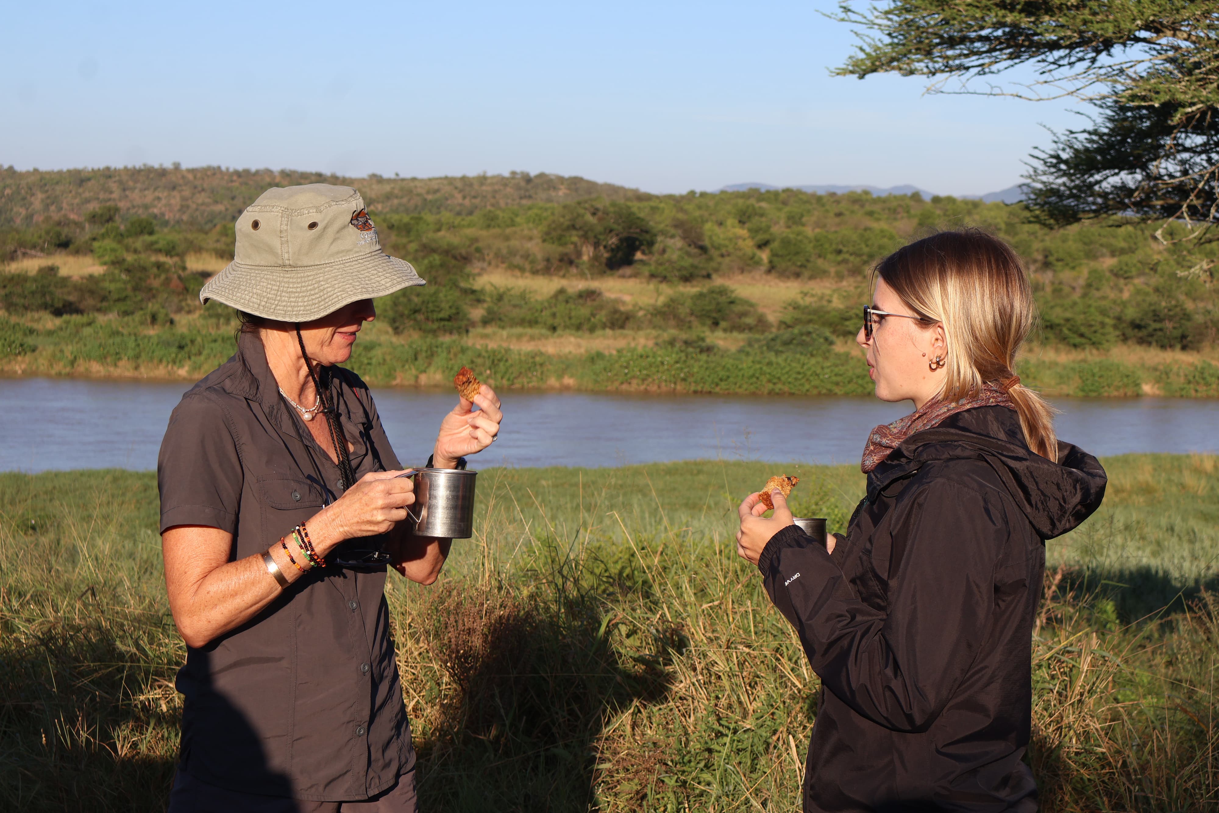 Two Wildlife ACT volunteers chatting over coffee and rusks during a field break.