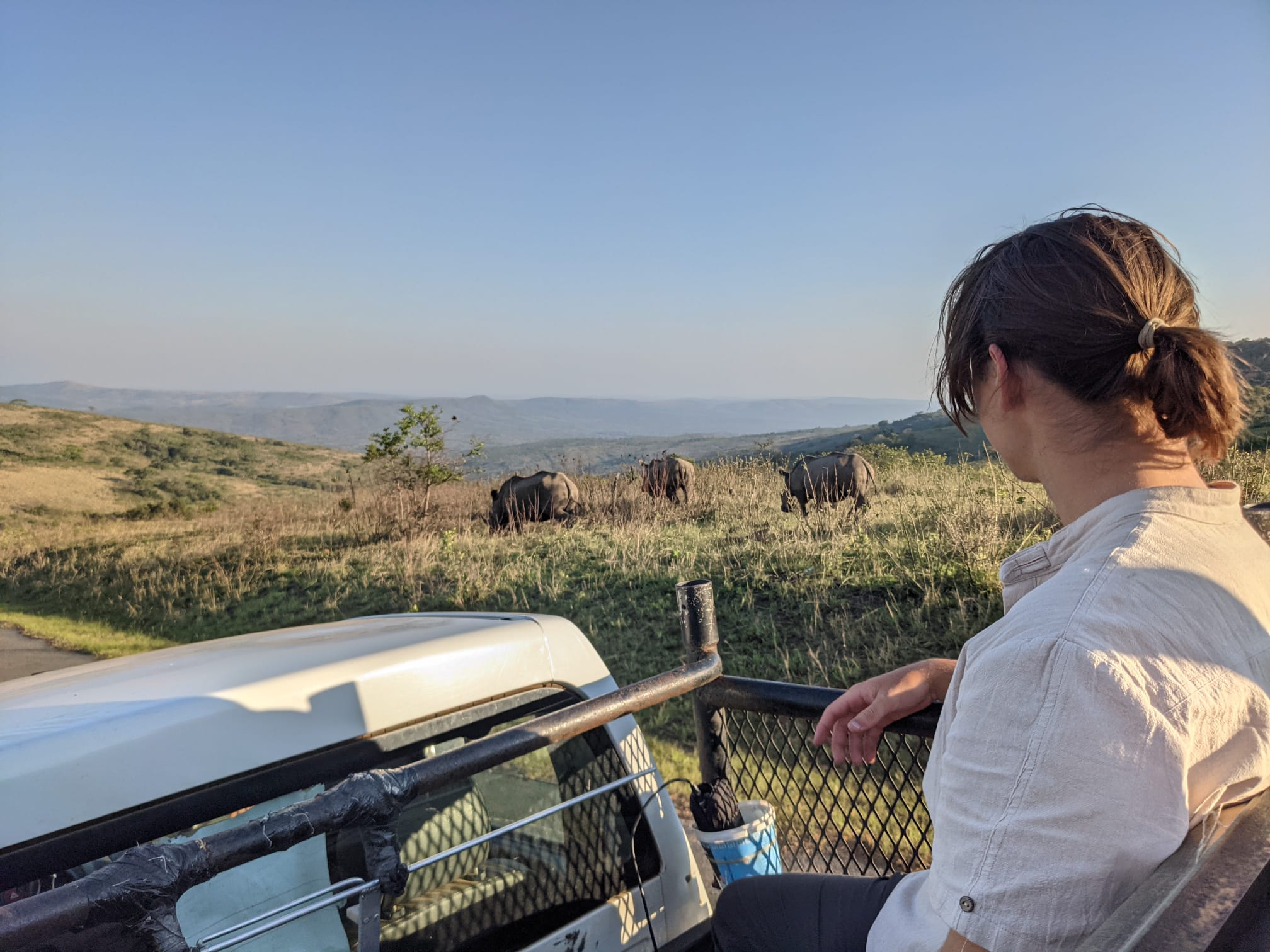 Student on a monitoring session with a Rhinoceros standing in the background