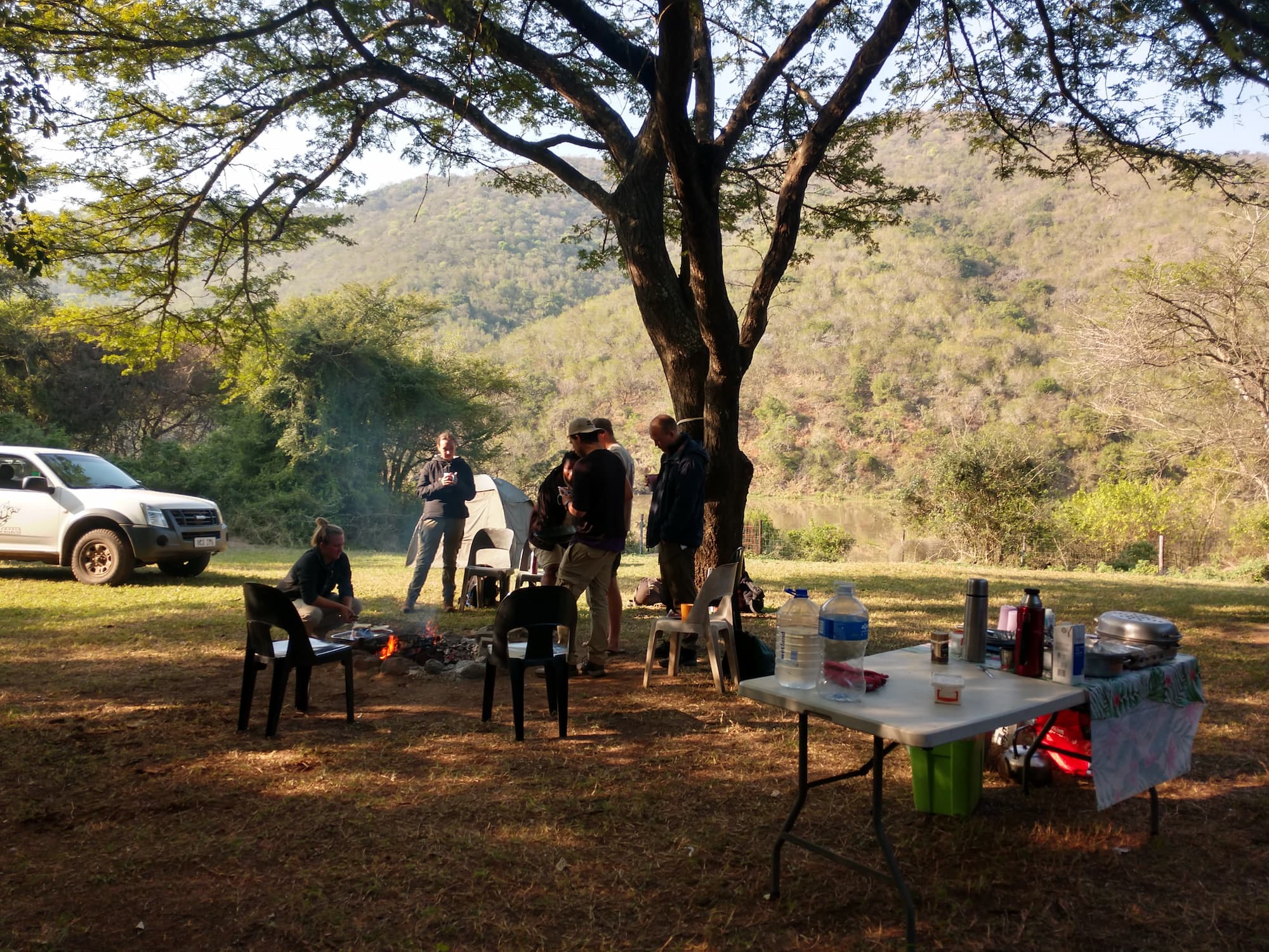 Students and Wildlife ACT monitors gathered around a braai at a bush campsite
