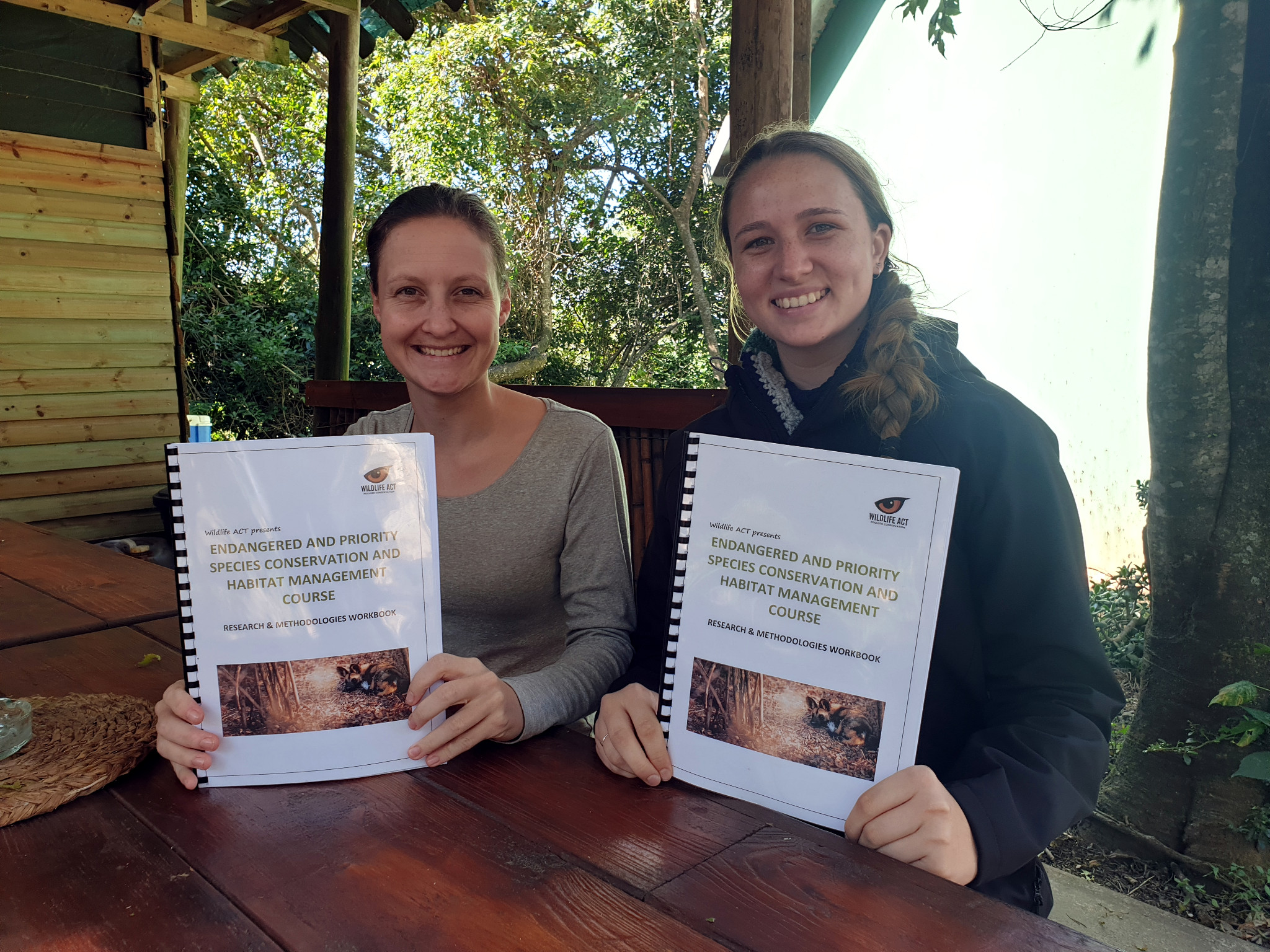 Two course participants holding their course materials