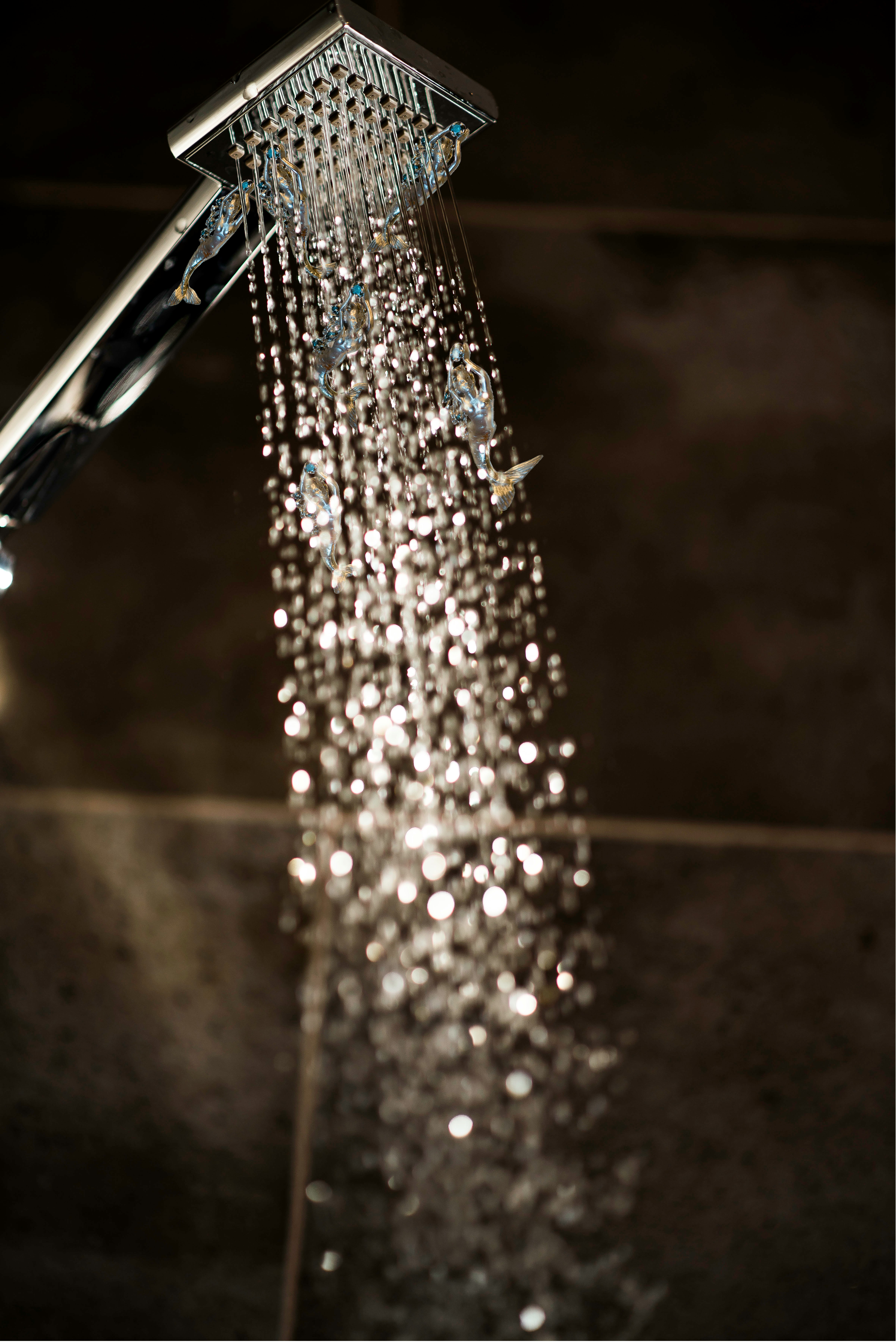 Water streaming from a shower head in a bathroom.