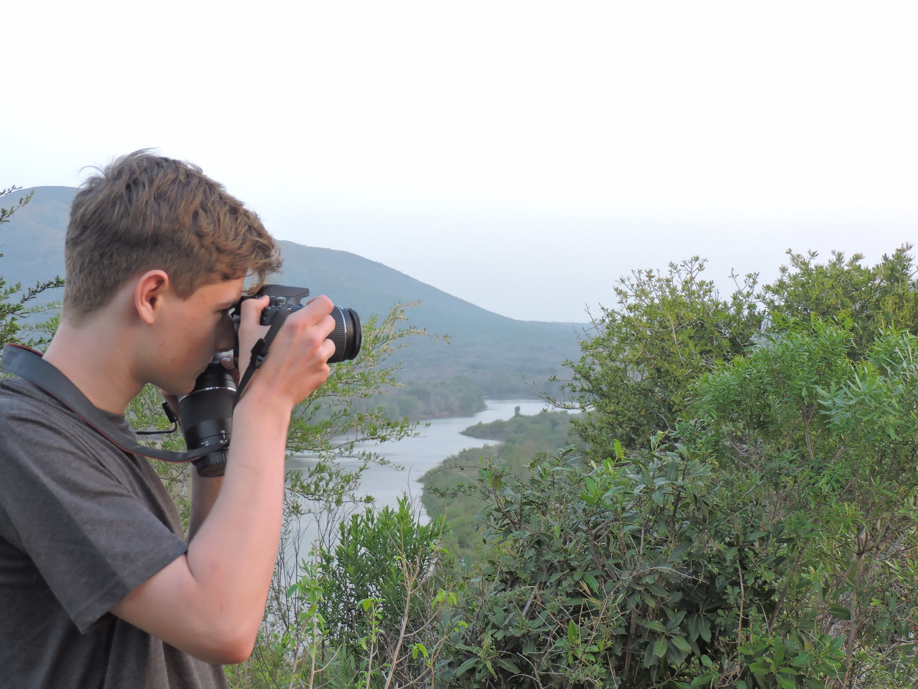 A young volunteer takes photos at a view point