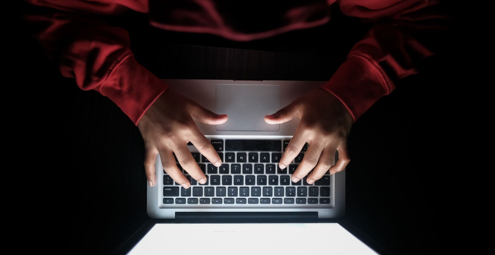 Iemand achter laptop in het donker