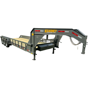 Truck towing a flatbed trailer at sunset