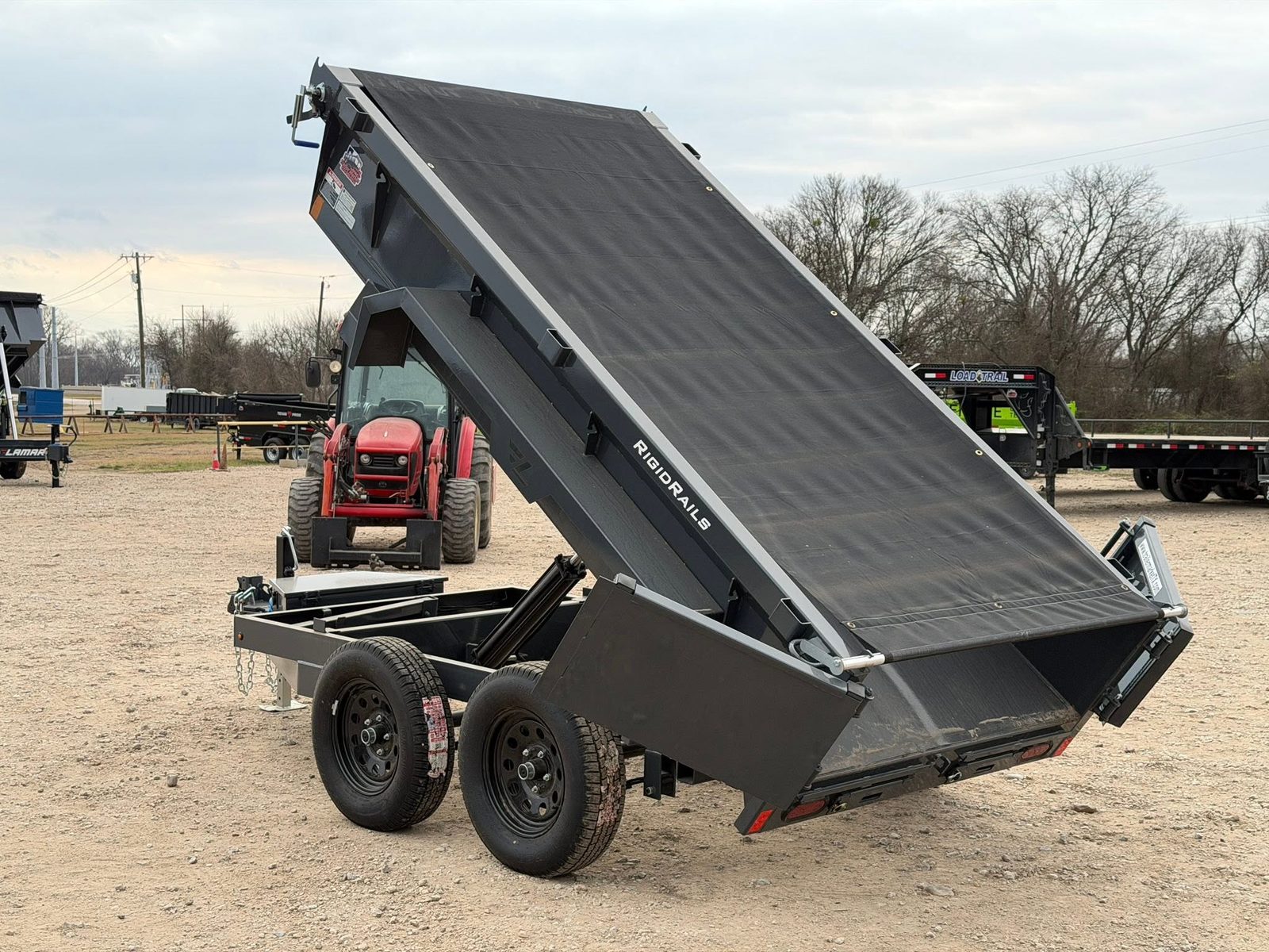 Truck towing a flatbed trailer at sunset