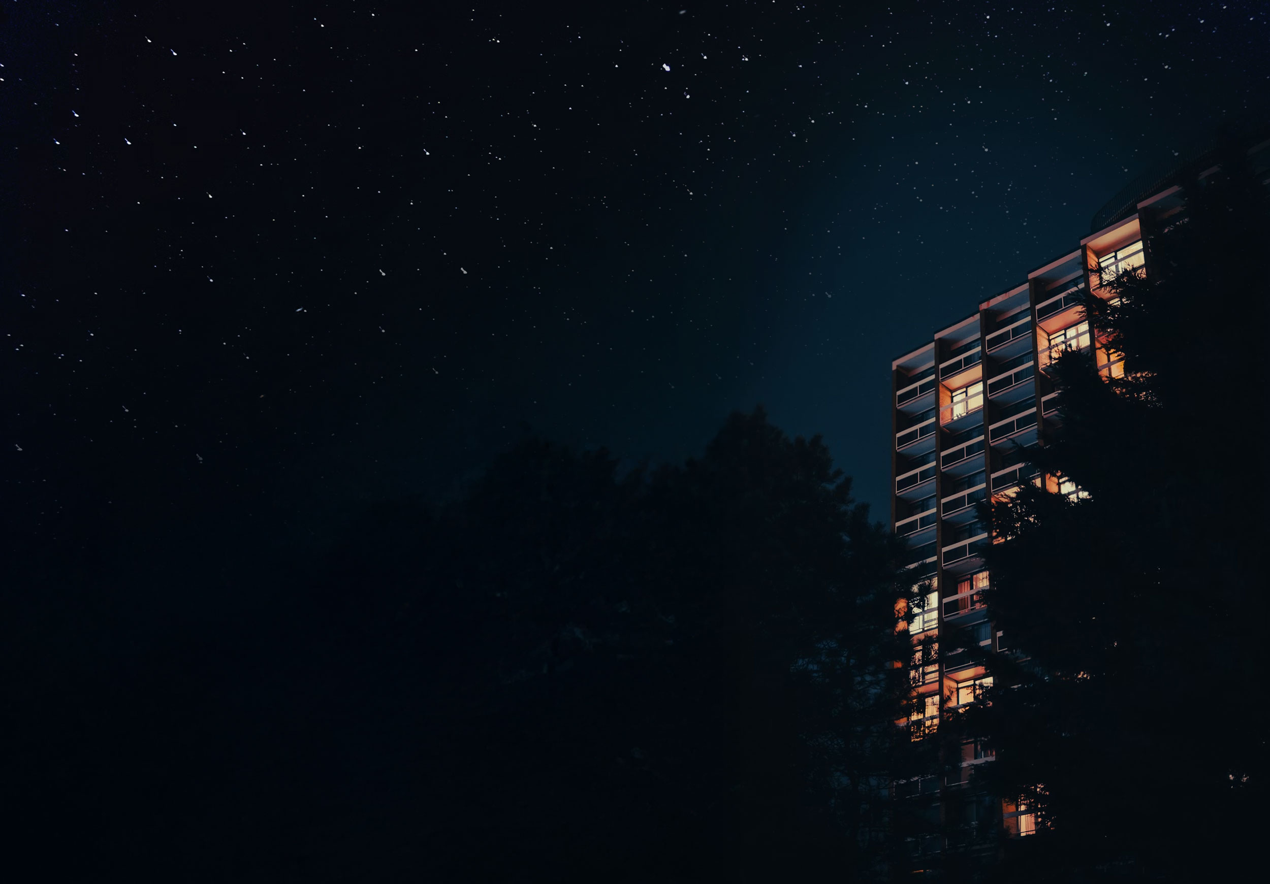 Nighttime exterior of Canopy 701 apartments surrounded by stars