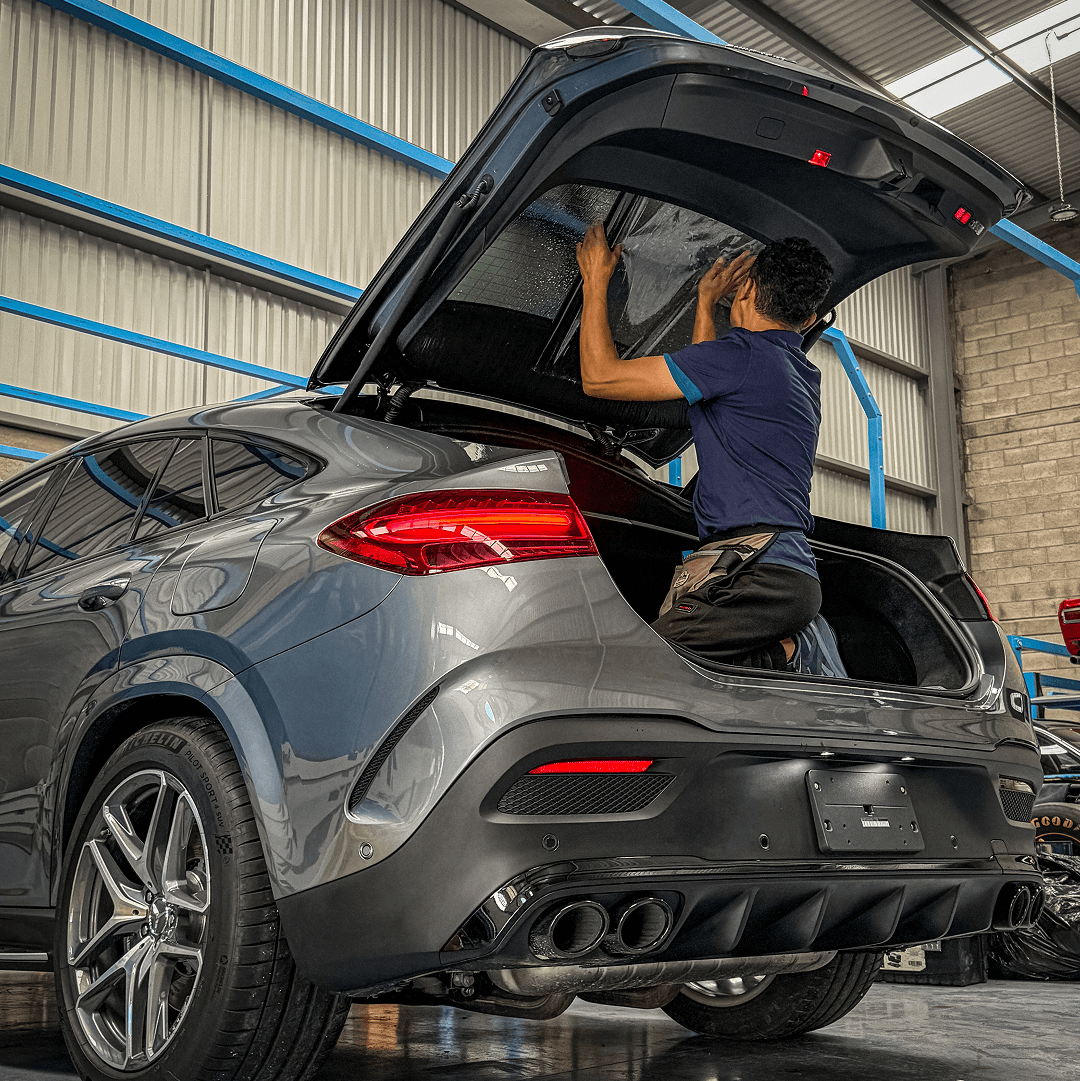 Técnico aplicando PPF en la parte trasera de un Mercedes GLE 53 AMG en taller especializado en Querétaro