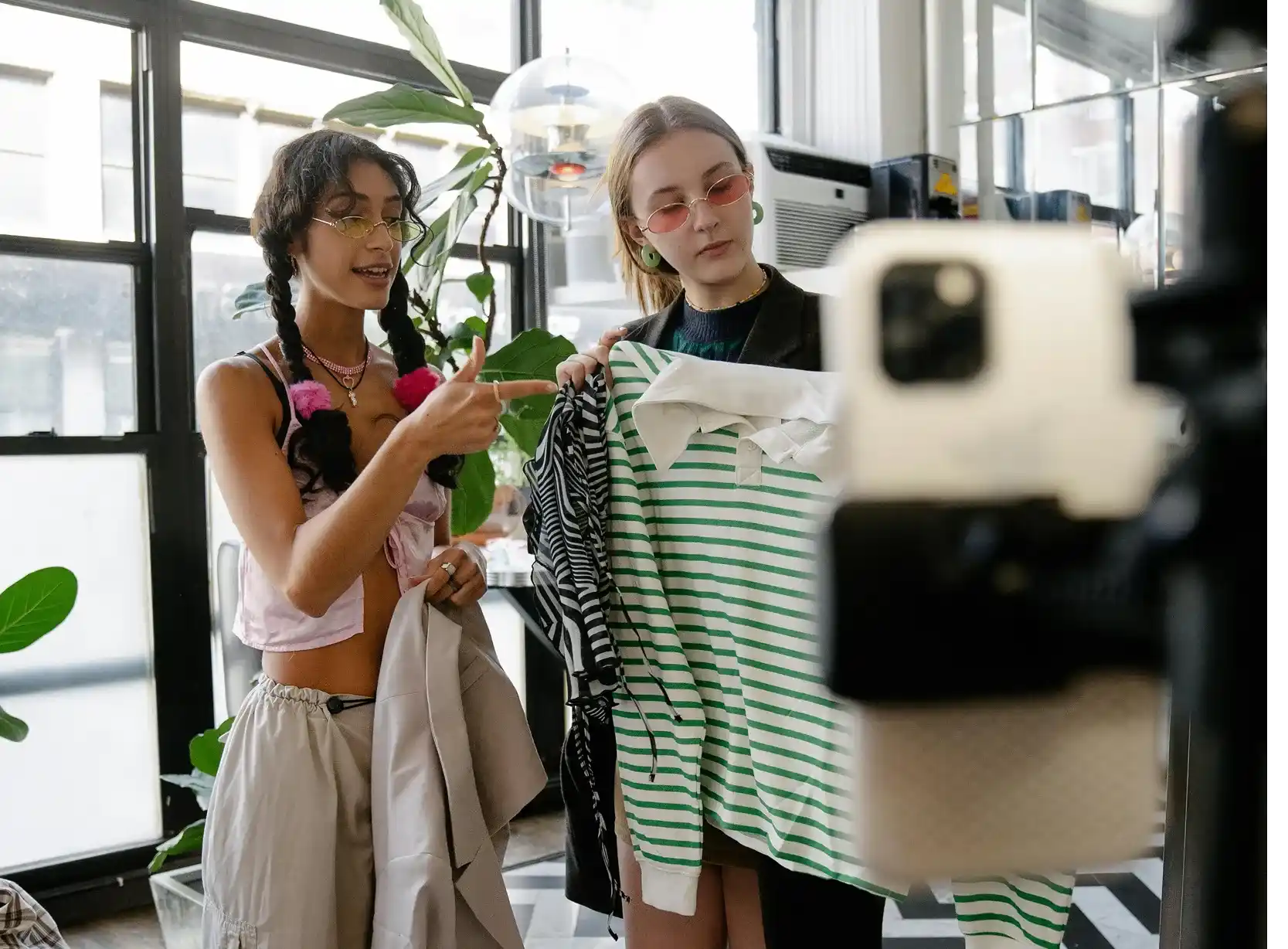 Zwei Frauen, die ein Live Shopping Stream mit Kleidung machen