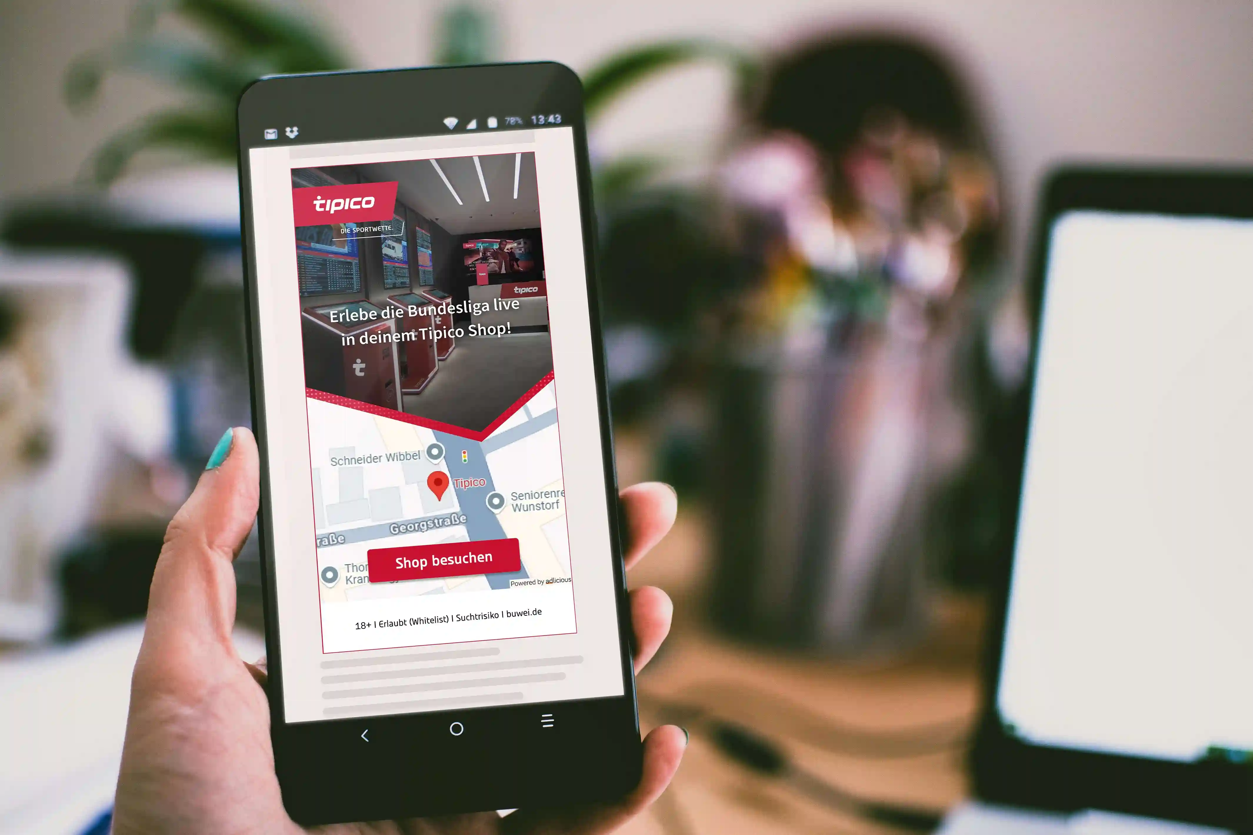 Hand hält Smartphone mit Tipico-Werbung