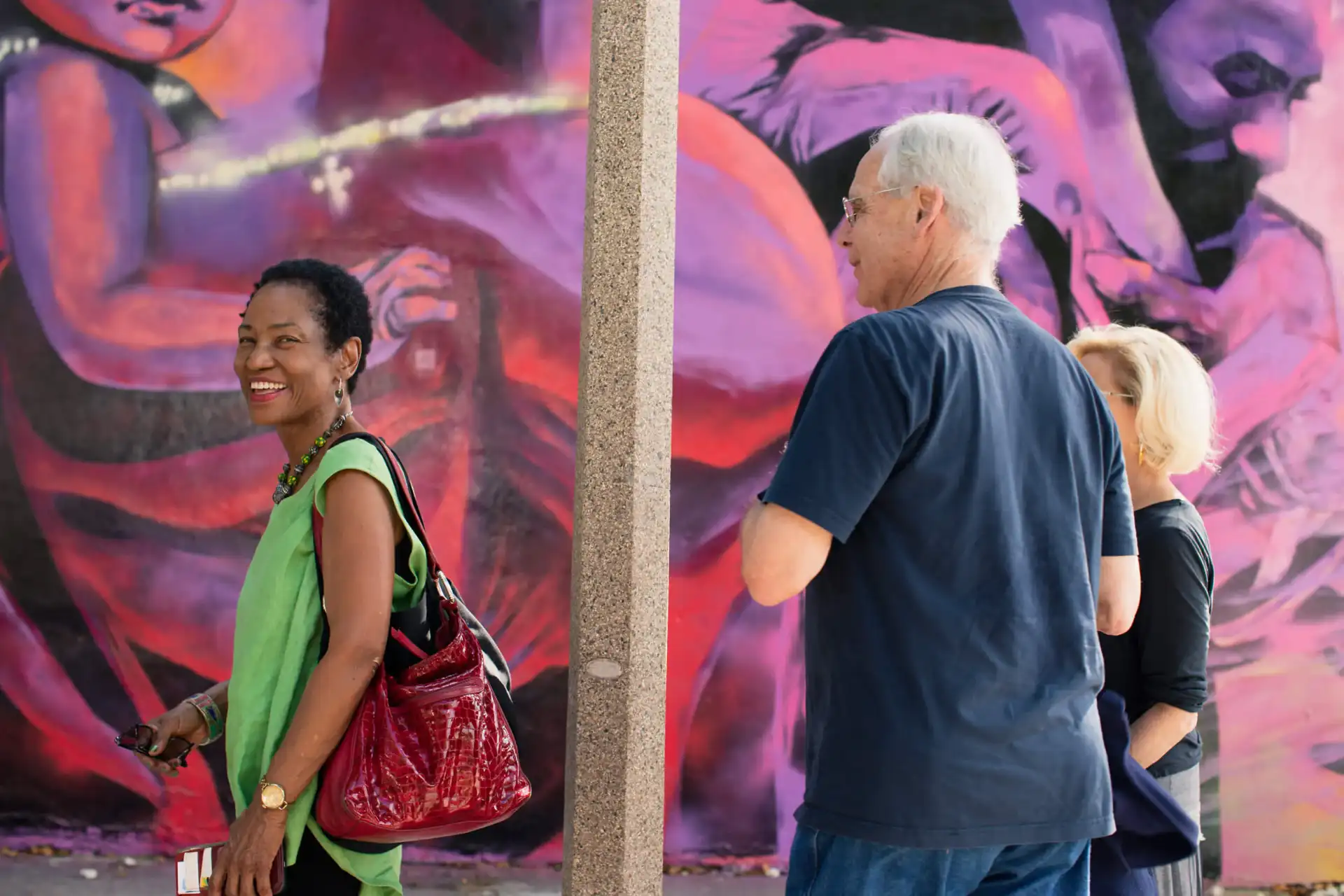People viewing vibrant artwork on a city street.