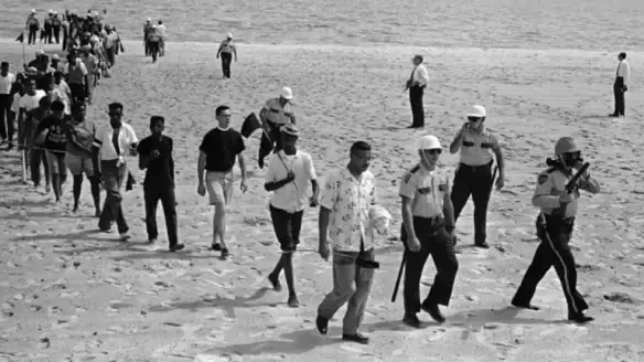 A historic beach with police and demonstrators.