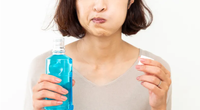  Woman using mouthwash for gums