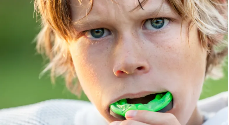 An athlete is wearing an athletic mouth guard