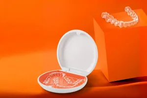  An image of an old retainer and a new retainer with tools and a dental model in the background