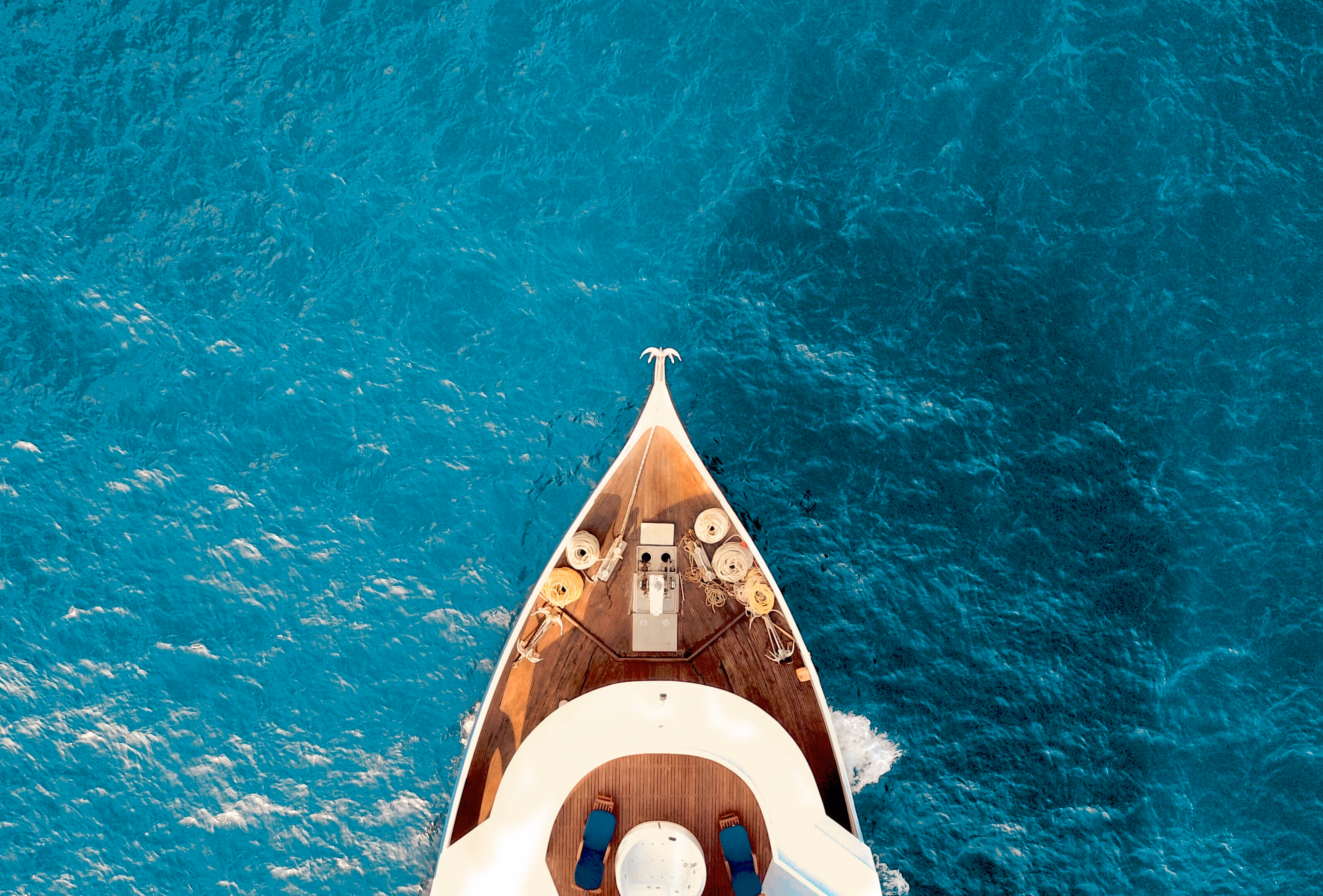 View from top over a ship front in blue transparent sea.