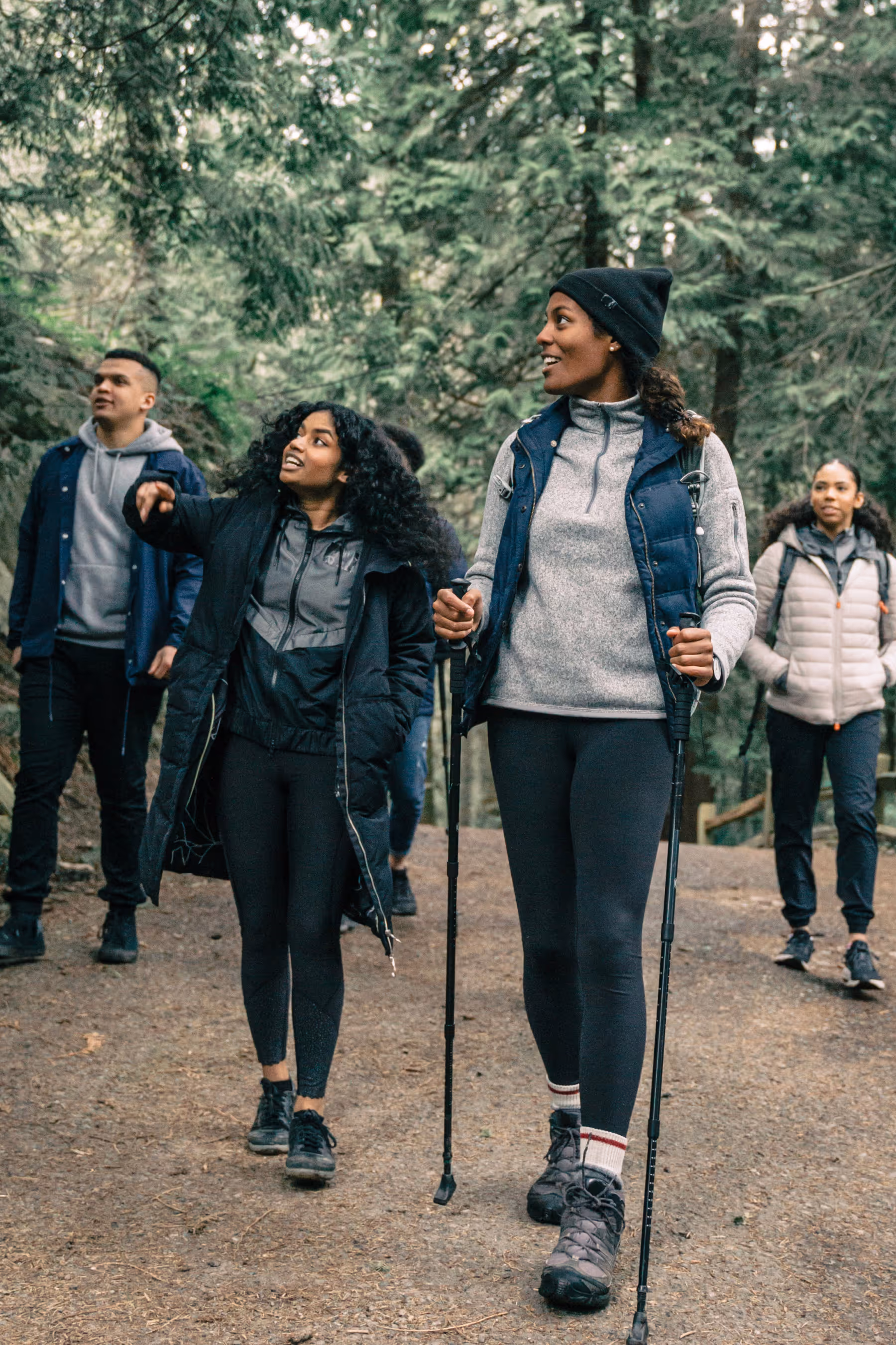 Group of four people in the woods exploring nature.