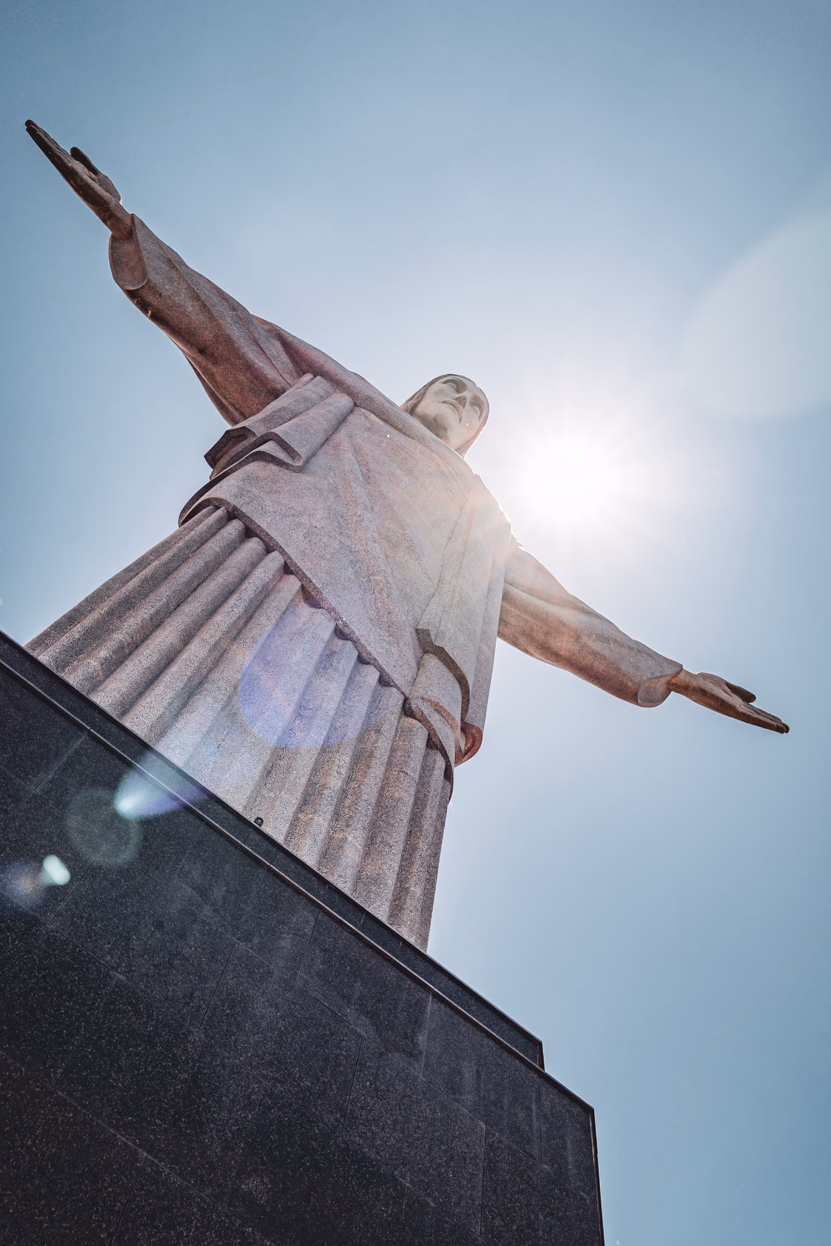 Jesus statue of Brazil observed from bottom and His back covering the sun light.