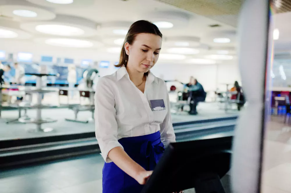 Une serveuse utilisant la caisse dans une cafeteria
