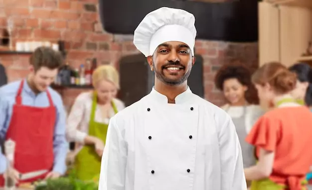 Cours de cuisine avec toque de chef indien masculin heureux