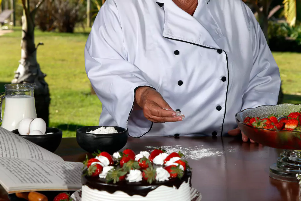 Pâtissier confectionnant des gâteaux aux fraises et au chocolat