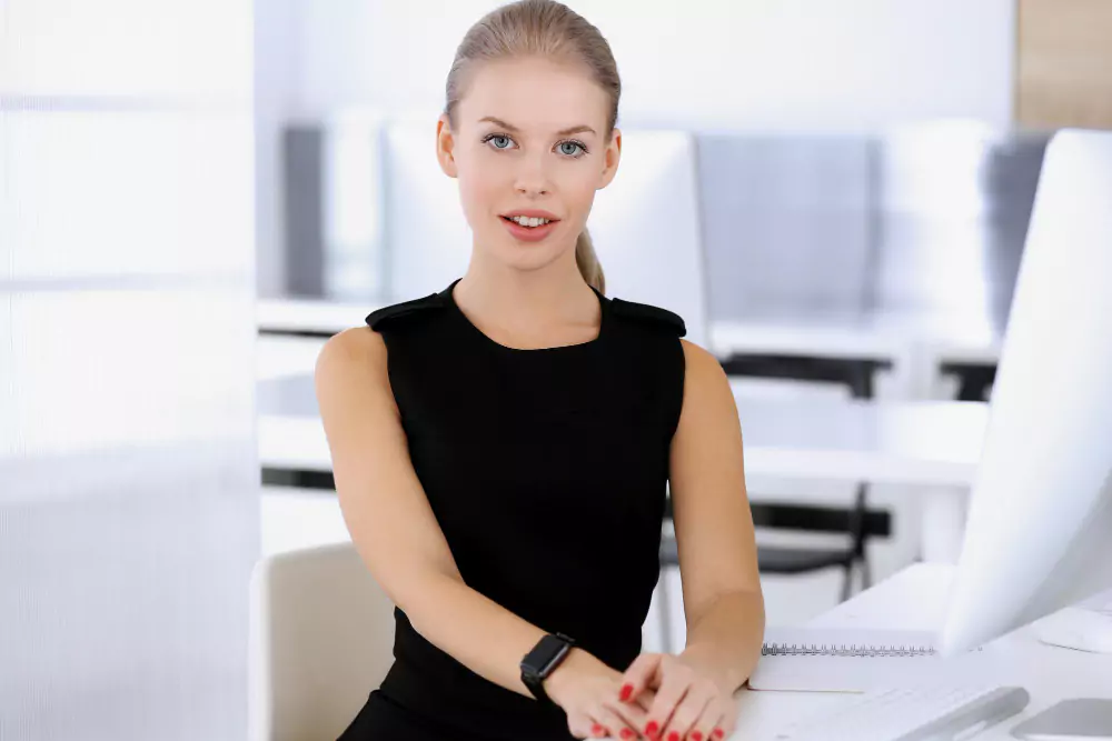 Femme d'affaires travaillant avec un ordinateur tout en étant assise au bureau dans un bureau moderne
