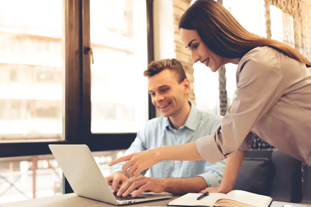 De beaux jeunes partenaires commerciaux utilisent un ordinateur portable.