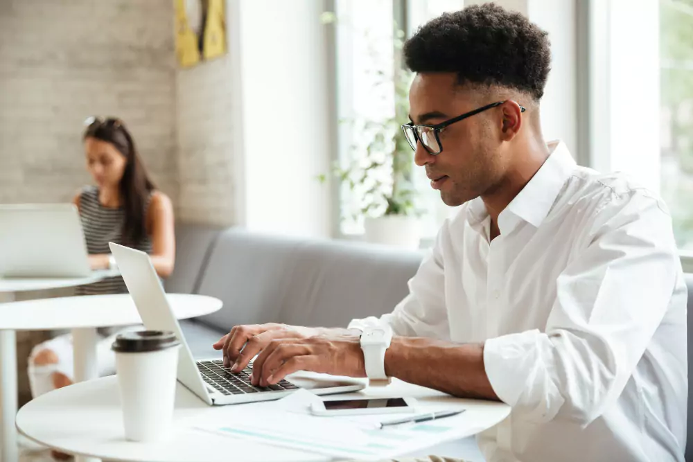 Jeune homme concentré assis en coworking