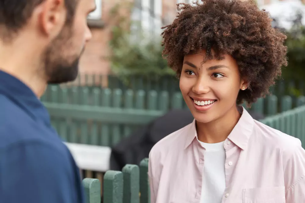 Une fille heureuse à la peau foncée parle à son camarade de groupe