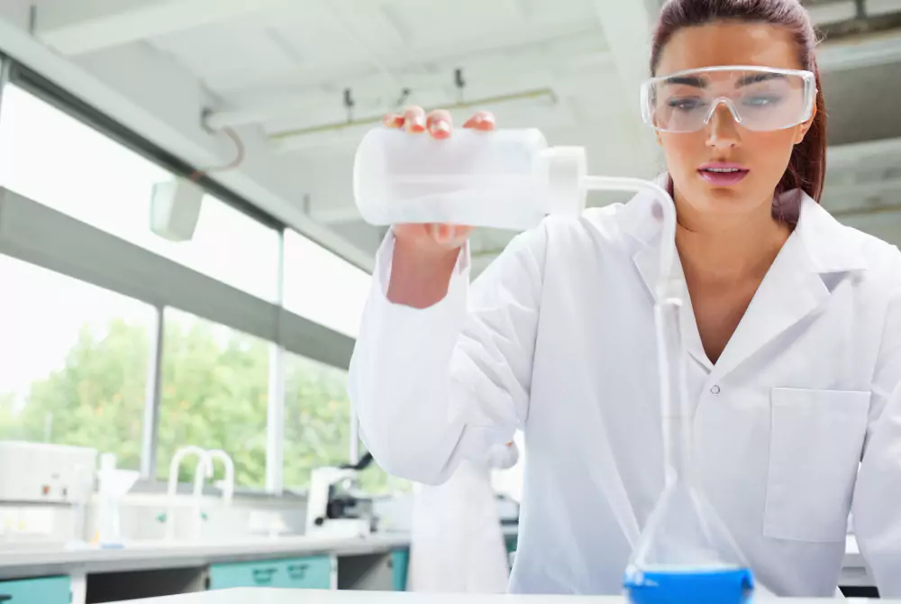 Étudiante en labo versant un liquide