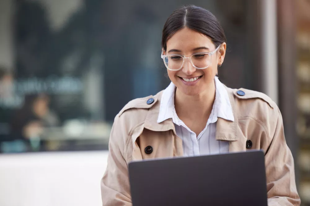 Femme utilisant un outil d'IA sur son laptop avec un sourire