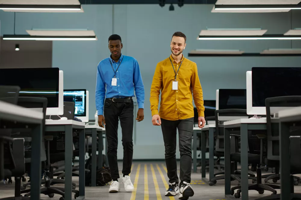 Deux responsables informatiques souriants travaillant dans un bureau IT